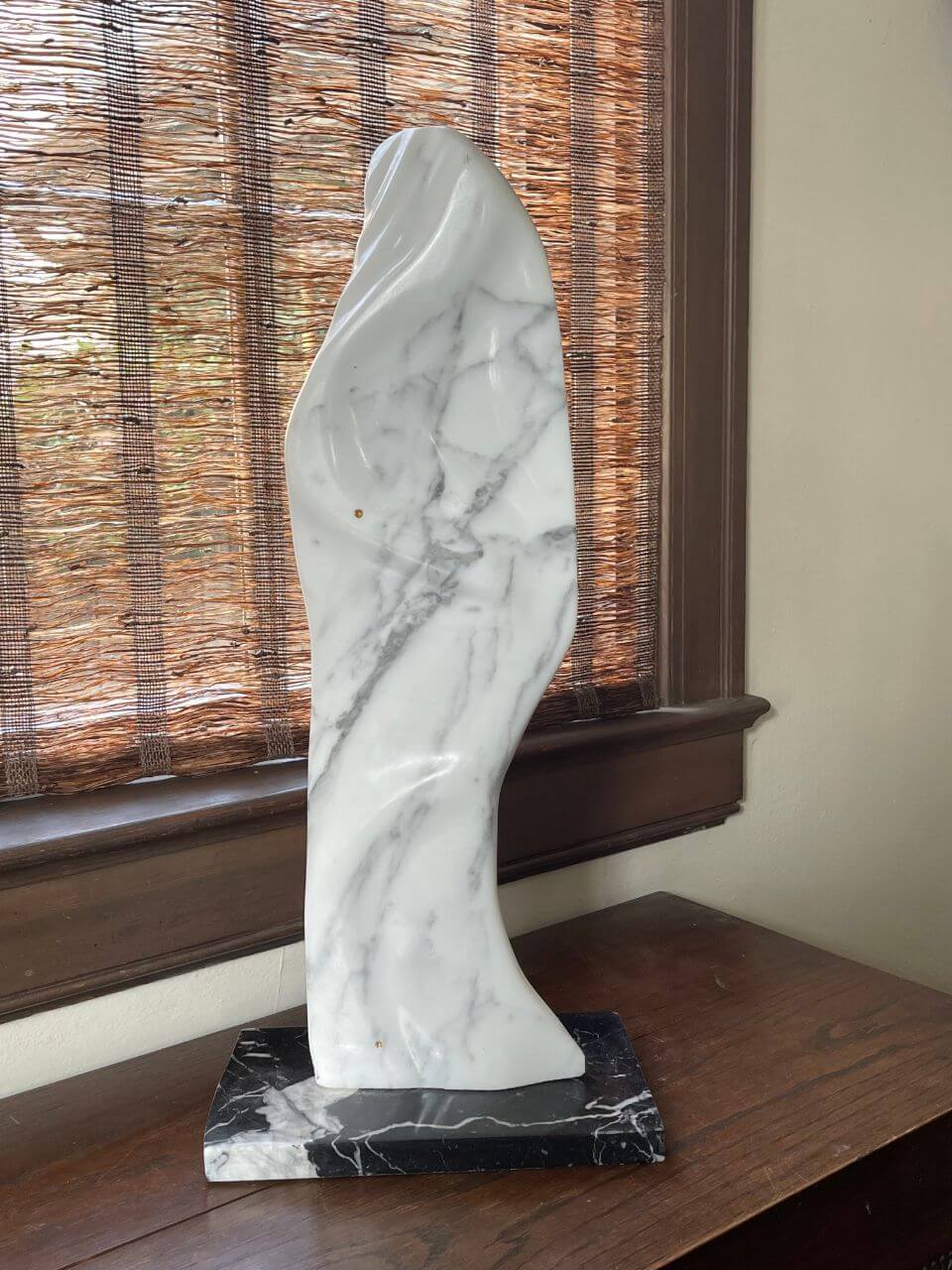 A tall marble lady, draped in a shawl to match the patterns of the stone